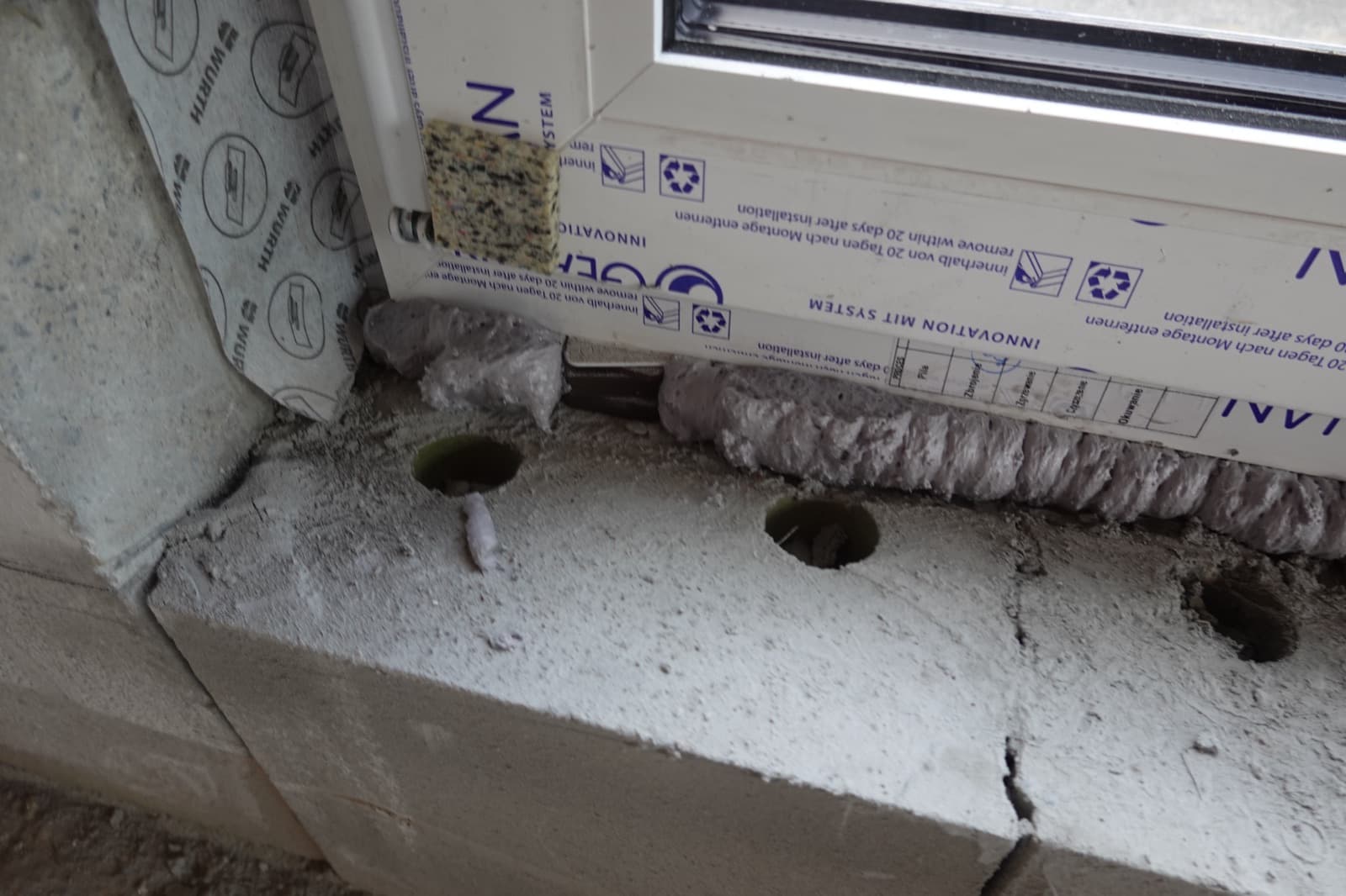 Mit Montageschaum ausgefüllter Anschluss unter einem Fensterrahmen