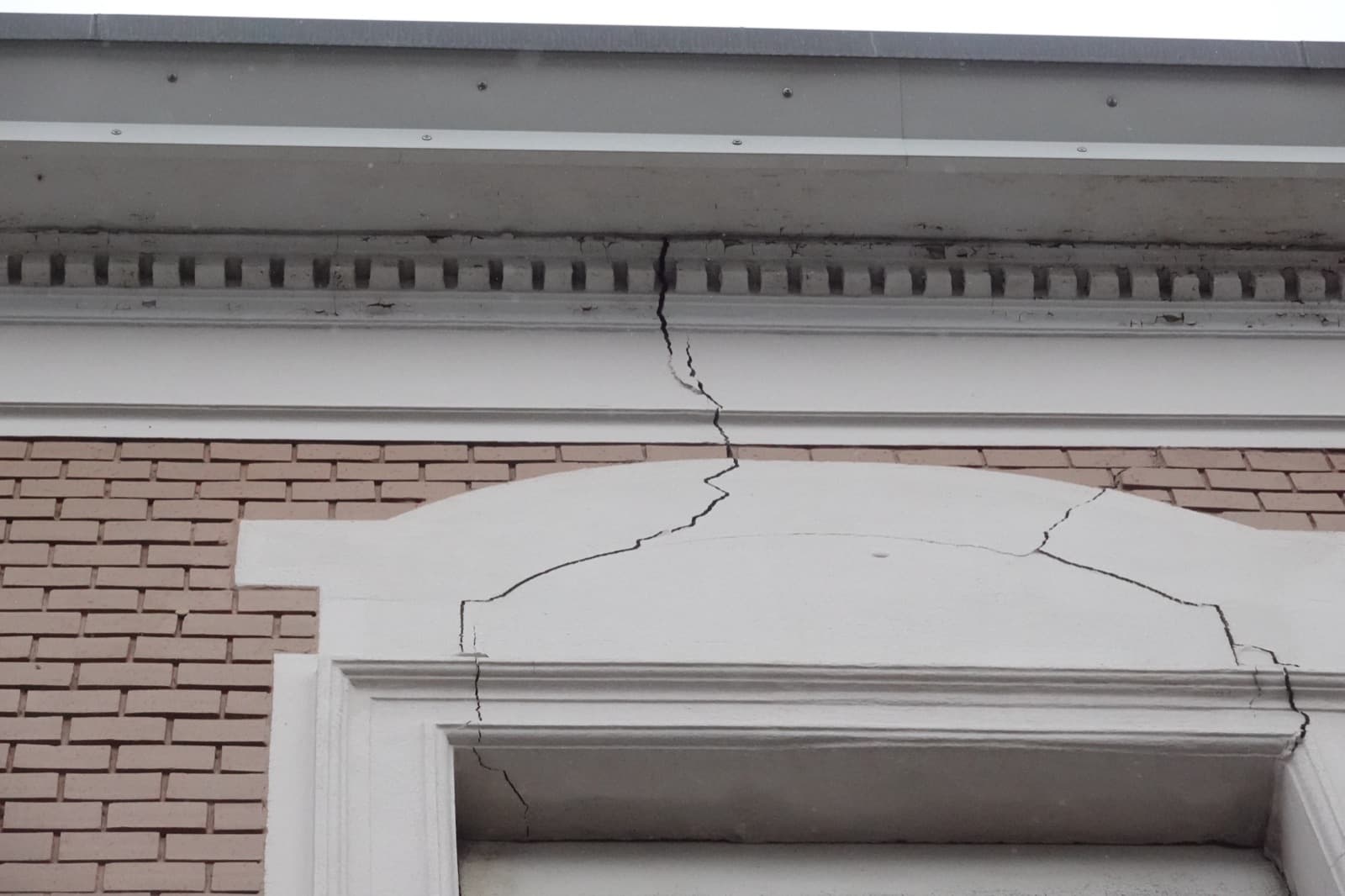 Riss im Putz oberhalb eines Fensters an der Außenfassade